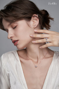 Lady wearing pearl earrings, ring and necklace