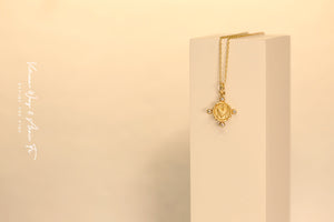 Yellow gold heart-shape coin necklace on a white object